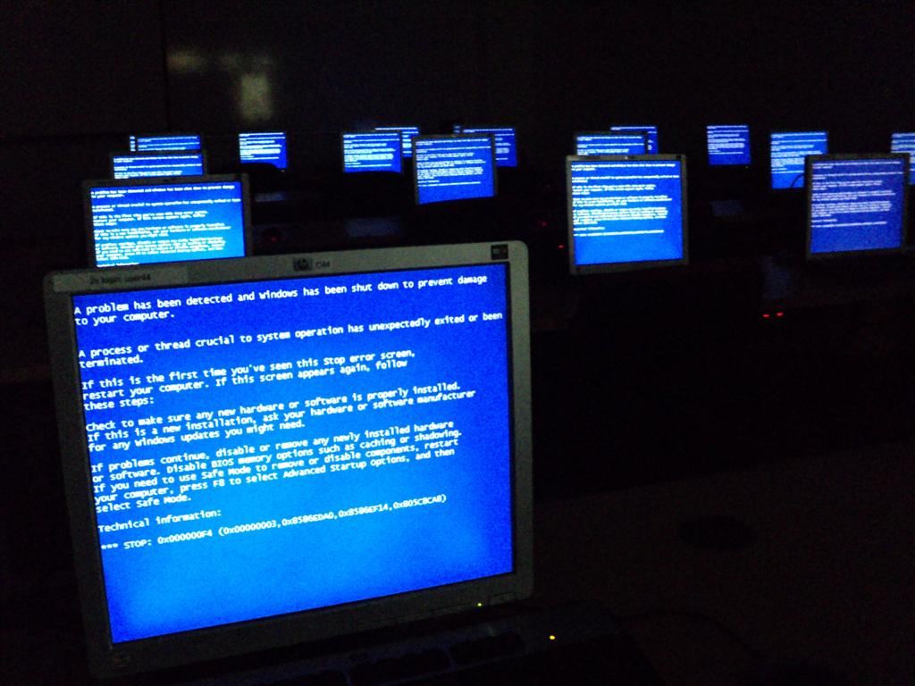 Room full of computers displaying the Windows Blue Screen of Death