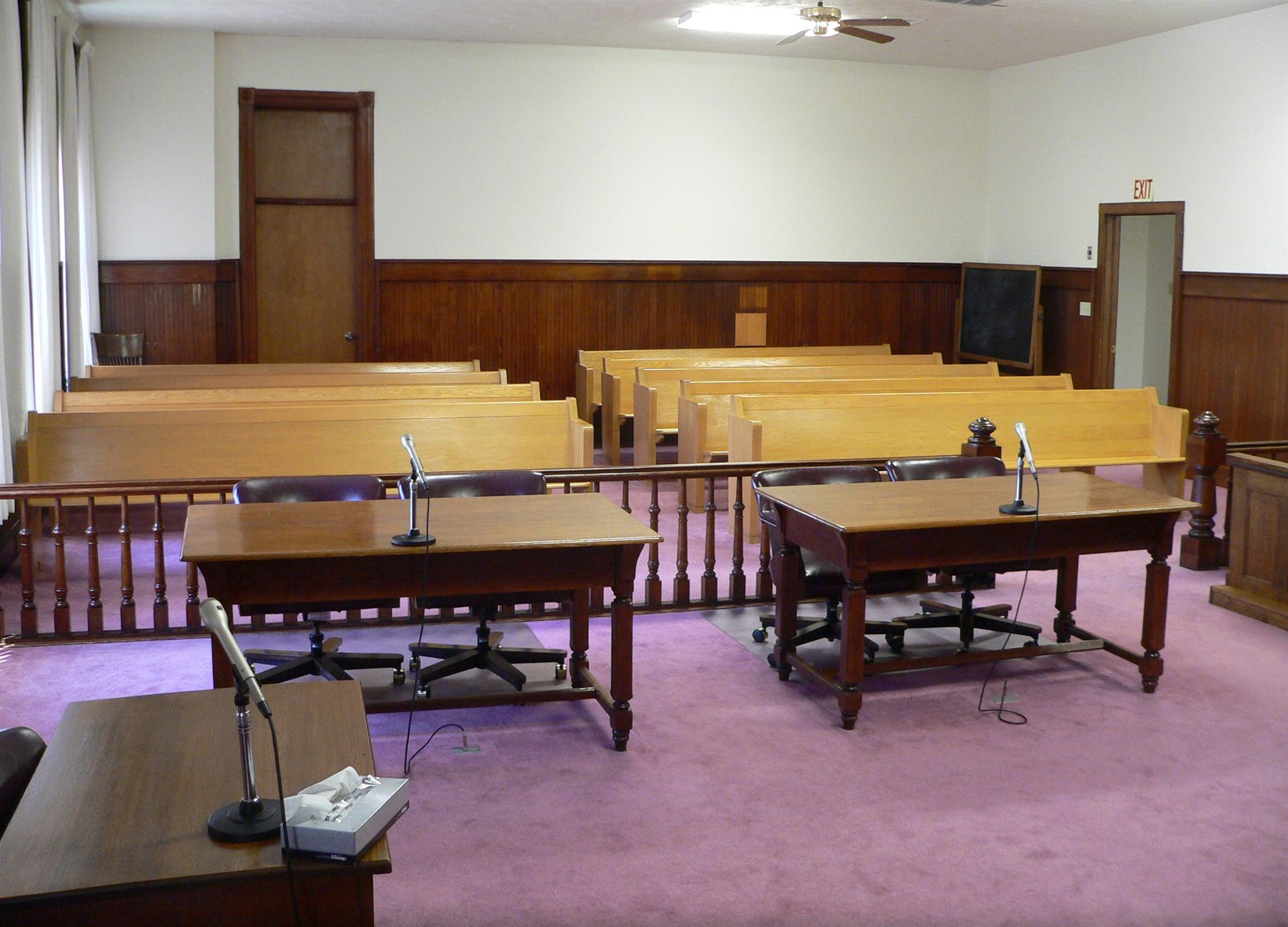 Empty courtroom with wooden benches and judge's bench